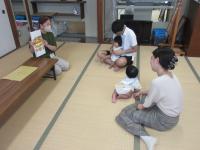 親の膝の上で絵本を見ている