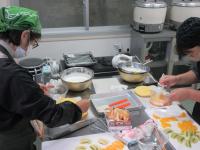 生地の間にクリームを塗っている