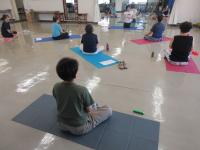 講師の説明を受講生がマットに座って聞いている